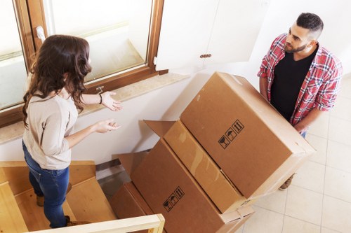 Professional movers handling desks and business furniture in Queens Park